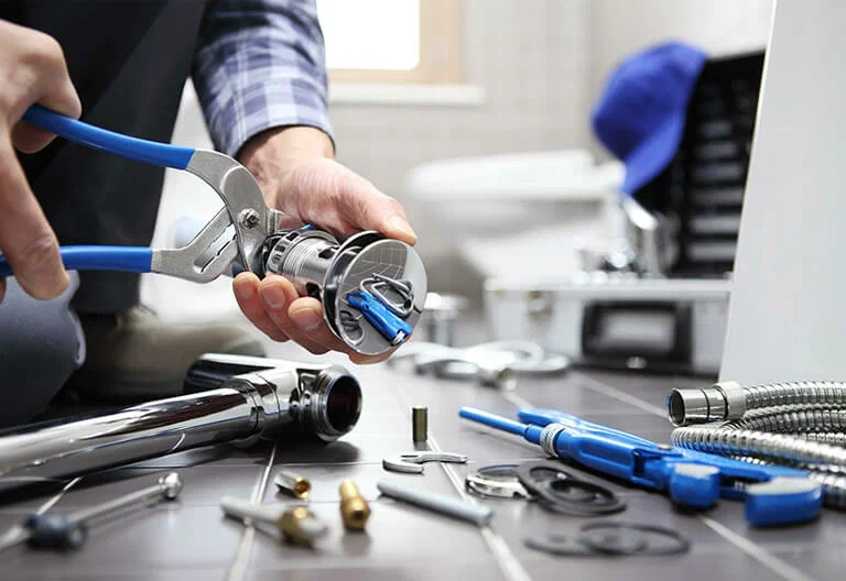 Technician repairing a plumbing fixture with professional tools in The Villages