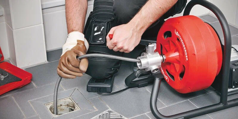 Plumber using a drain-cleaning machine in The Villages