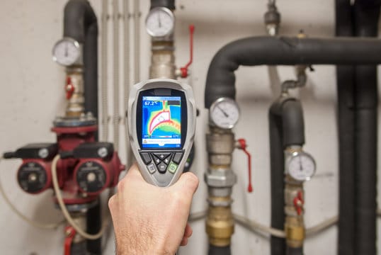Plumber using a thermal imaging camera to inspect pipes in The Villages