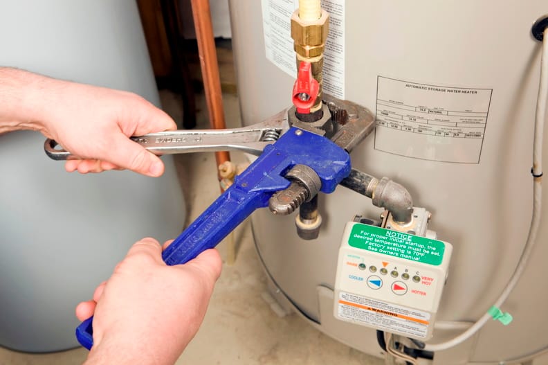 Plumber repairing a water heater valve in The Villages
